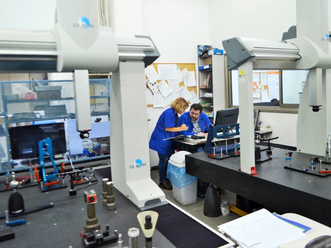 Two inspectors working between coordinate measuring machines