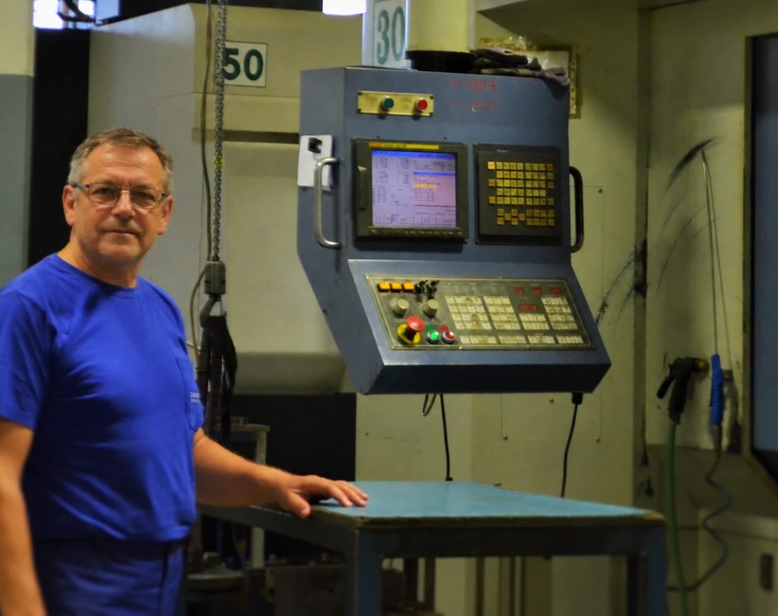 Operator standing beside a CNC machining centre
